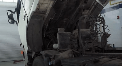 Tilt the truck cab to reach the radiator cap or coolant reservoir cap.